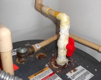 What causes the powdery crust on CPVC pipe connections at the water heater?